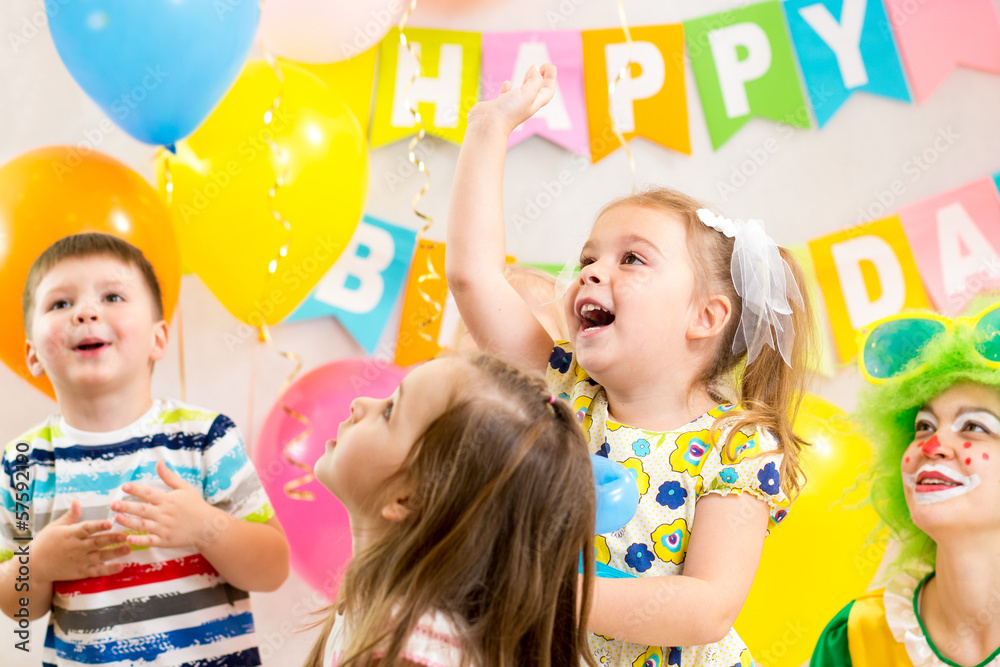 Fototapeta premium jolly kids group with clown celebrating birthday party