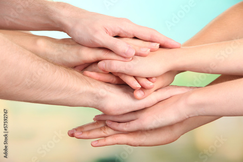 United hands on bright background. Conceptual photo of teamwork