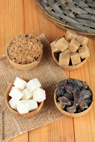 Different types of sugar in bowls on table close-up