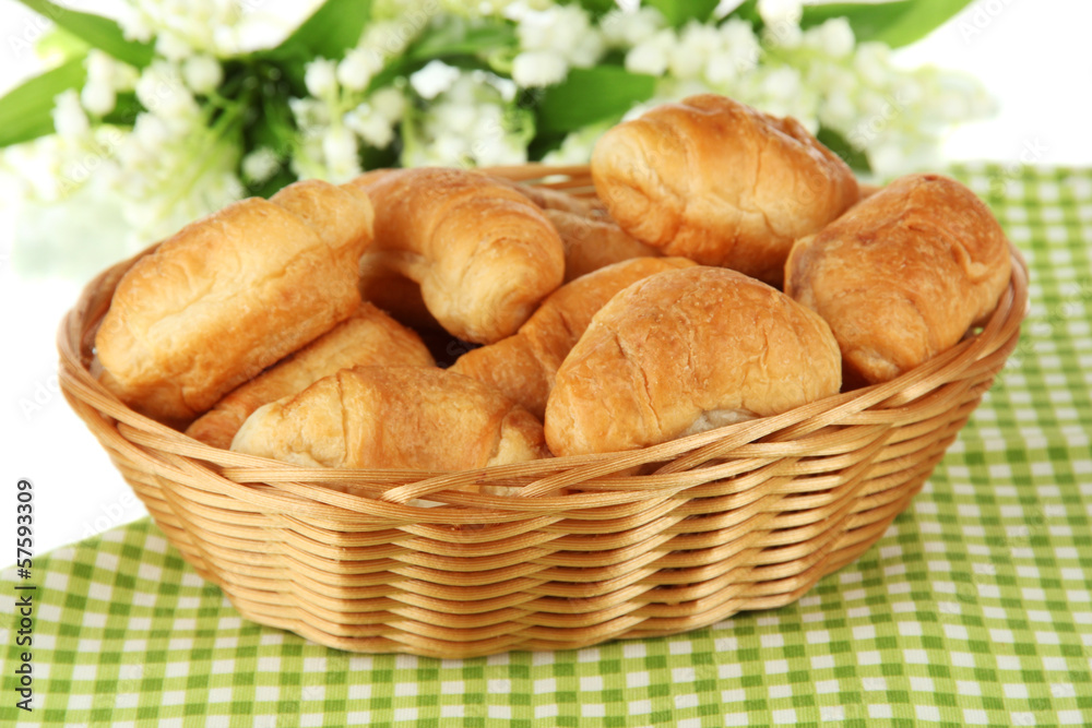 Tasty croissants in wicker basket on table on white background Tasty croissants in wicker basket on table on white background