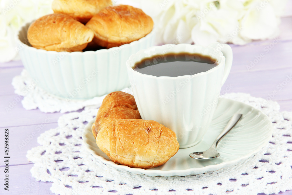 Tasty croissants and cup of coffee on table close-up Tasty croissants and cup of coffee on table close-up