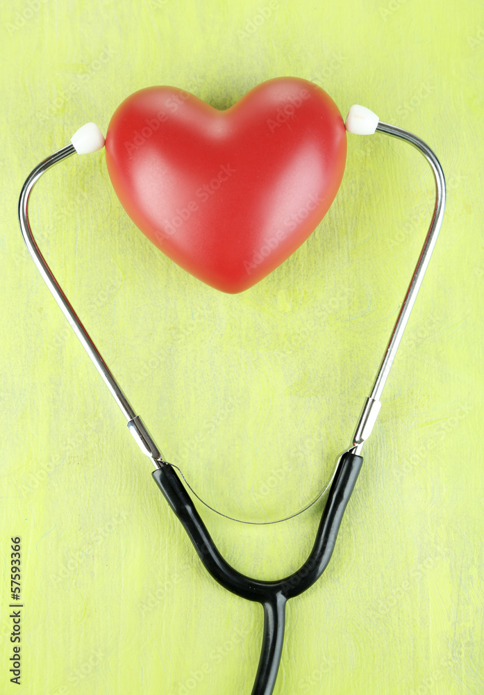 Stethoscope and heart on wooden table close-up Stethoscope and heart on wooden table close-up