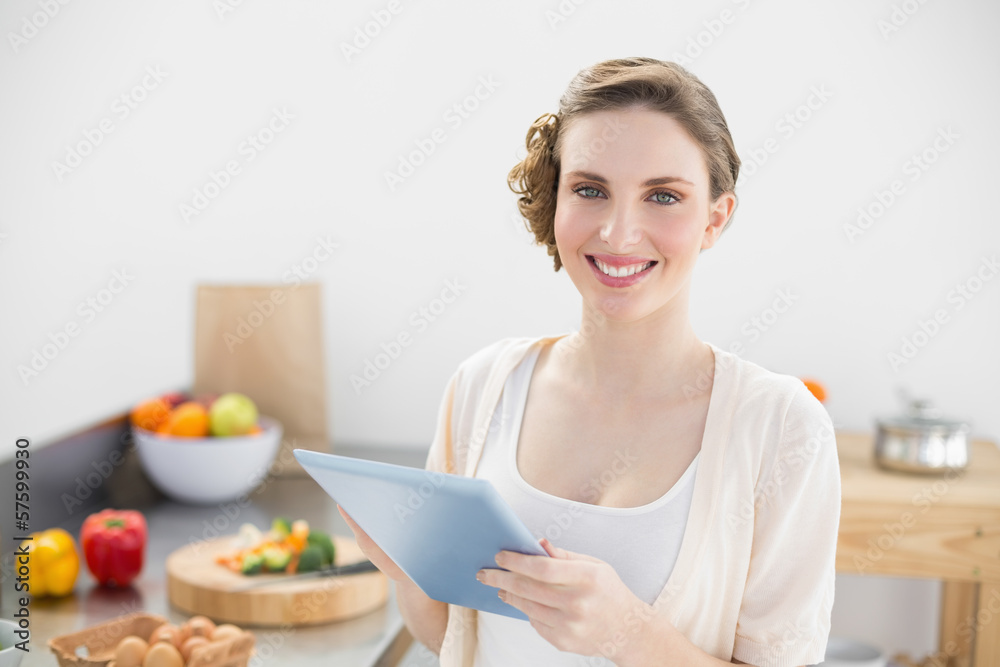 Young gorgeous woman using her tablet smiling at camera Young gorgeous woman using her tablet smiling at camera