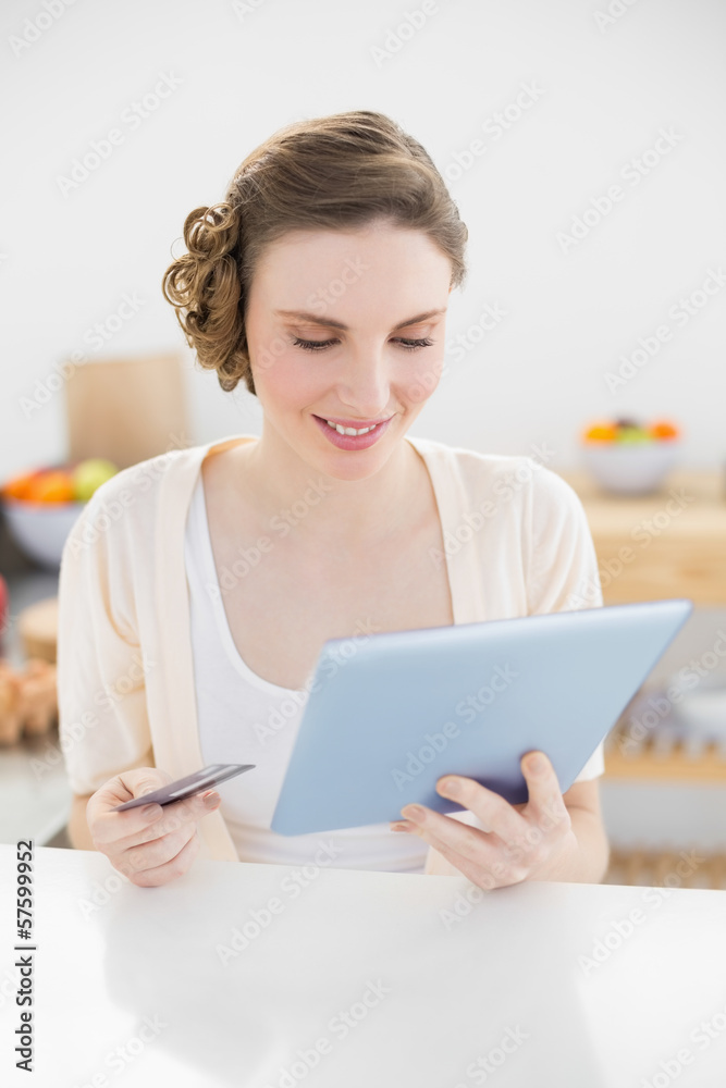 Pretty woman using her tablet for home-shopping while sitting in Pretty woman using her tablet for home-shopping while sitting in