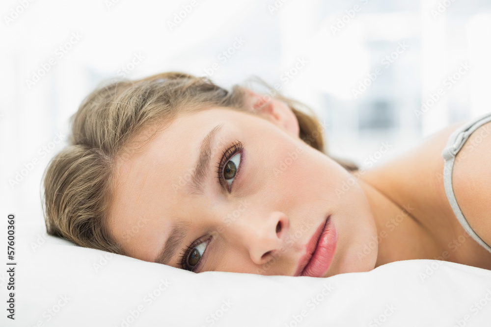 Tired woman lying in her bed looking irritated Tired woman lying in her bed looking irritated