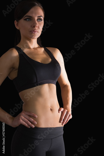 Beautiful sporty woman posing in sportswear with her hands on hi