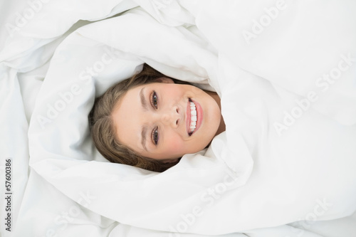 Content relaxed woman lying in her bed under the cover