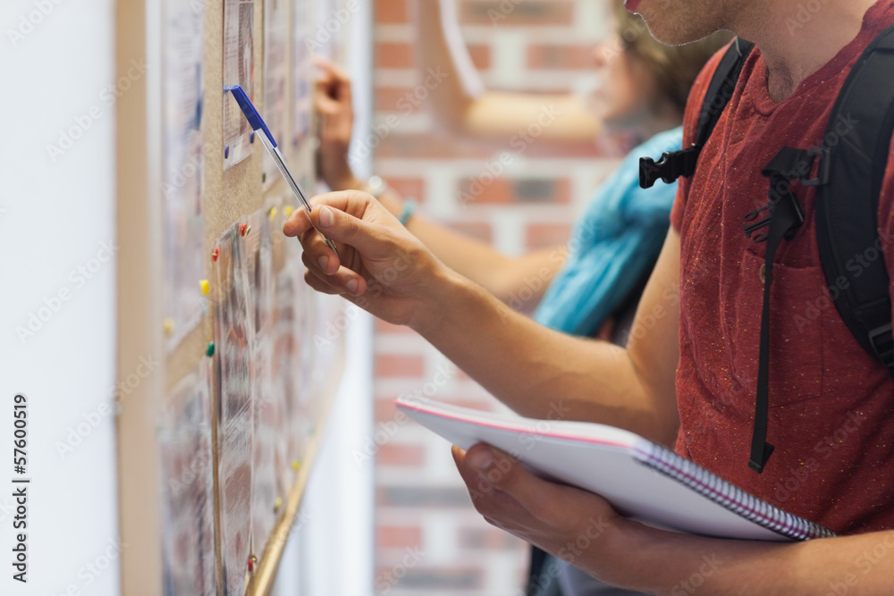 Obraz premium Casual students searching something on notice board