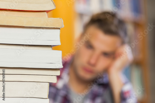 Student studying between piles of books