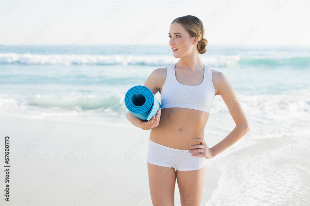 Beautiful slender woman holding rolled up exercise mat Beautiful slender woman holding rolled up exercise mat