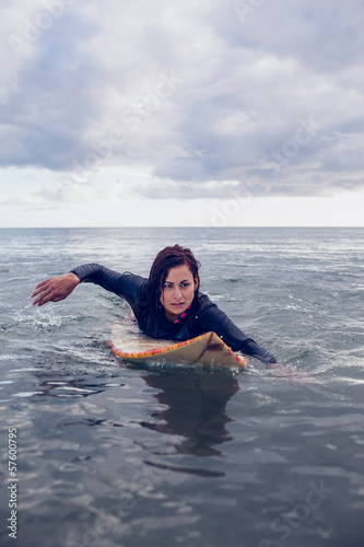 Woman swimming over surfboard in water © WavebreakmediaMicro
