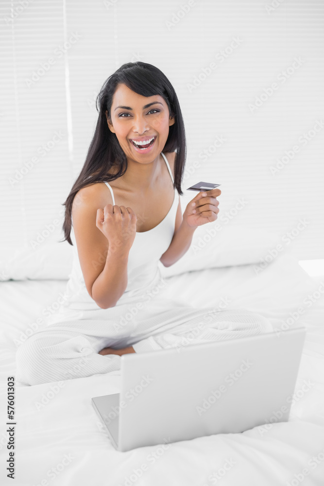Cheering lovely woman home shopping with her notebook Cheering lovely woman home shopping with her notebook