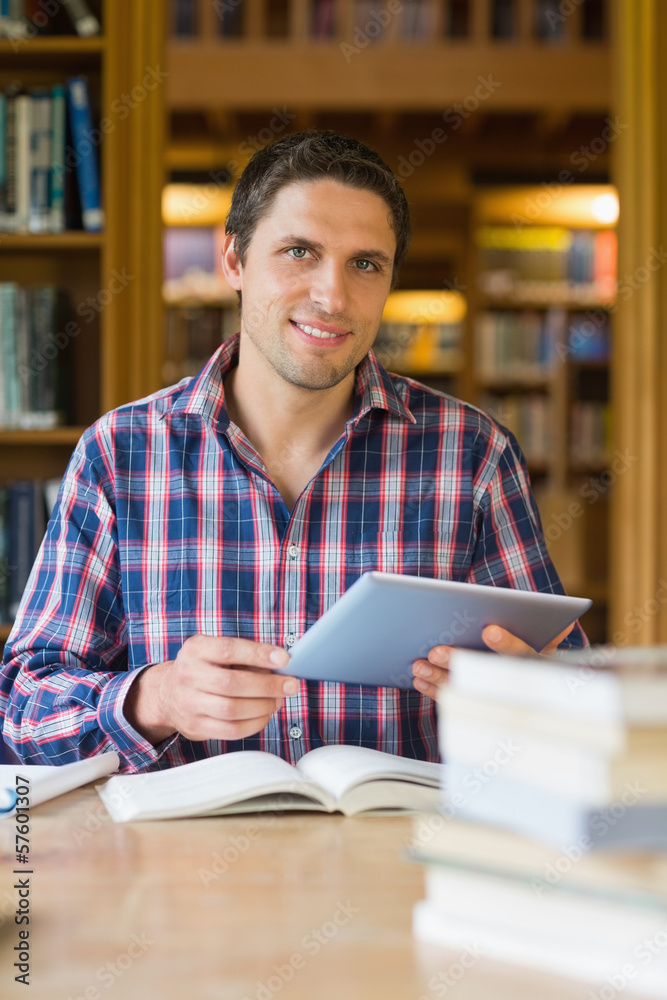 Happy mature student holding tablet PC in the library Happy mature student holding tablet PC in the library