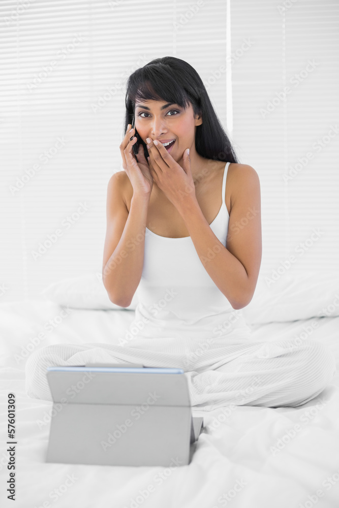 Attractive yawning woman sitting on her bed