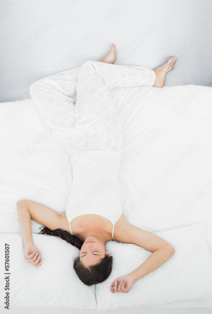 Full length of a woman sleeping in bed with eyes closed Full length of a woman sleeping in bed with eyes closed