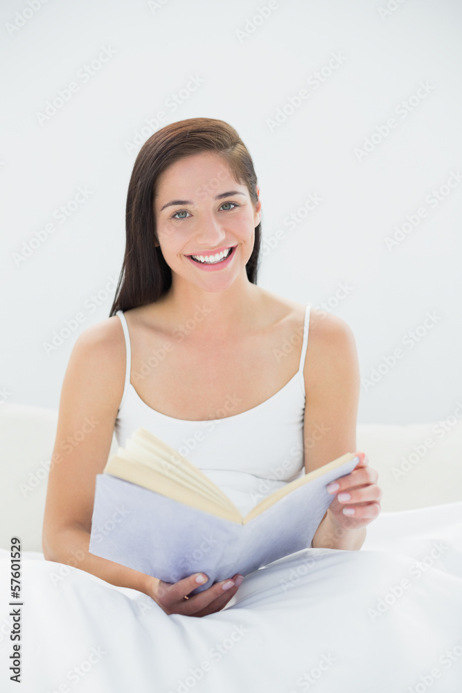 Portrait of a smiling woman with book in bed Portrait of a smiling woman with book in bed