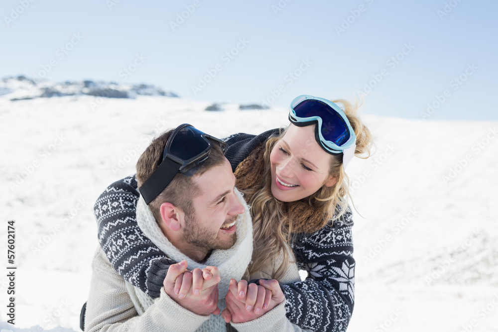 Close-up of a cheerful couple with ski goggles on snow