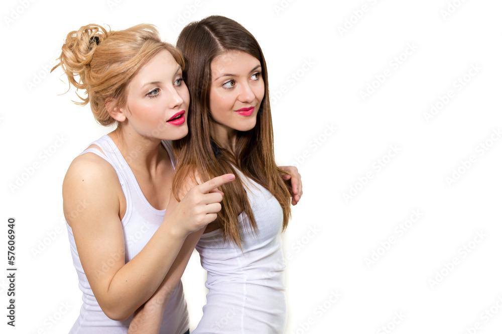 Two female friends showing on copy space on white