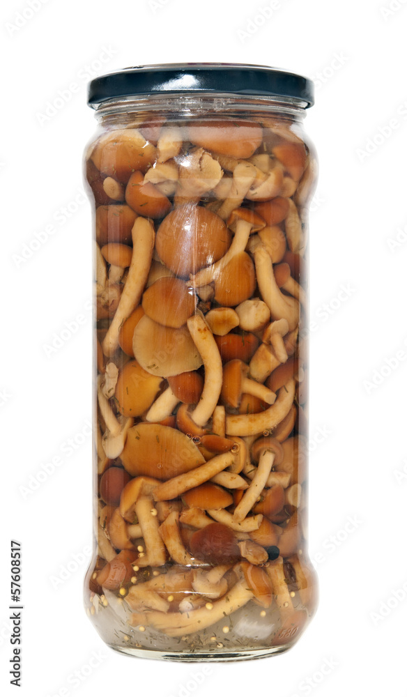Glass jar with assorted marinated mushrooms on the white backgro Glass jar with assorted marinated mushrooms on the white backgro