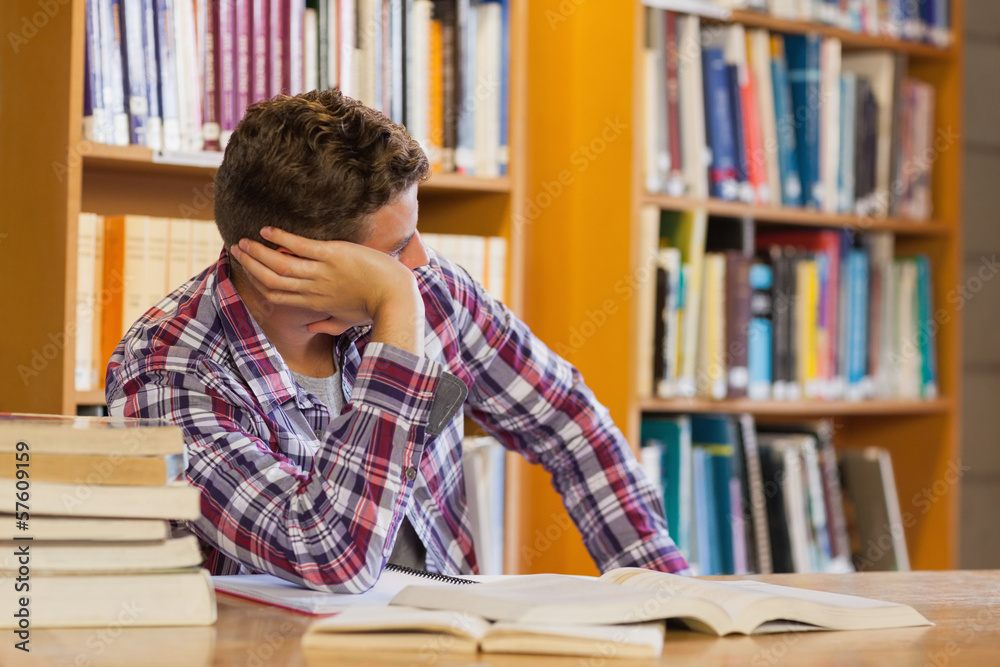 Handsome distracted student studying his books Handsome distracted student studying his books