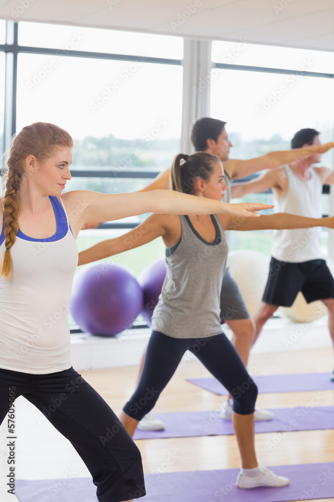 Fototapeta premium Sporty people stretching hands at yoga class in fitness studio