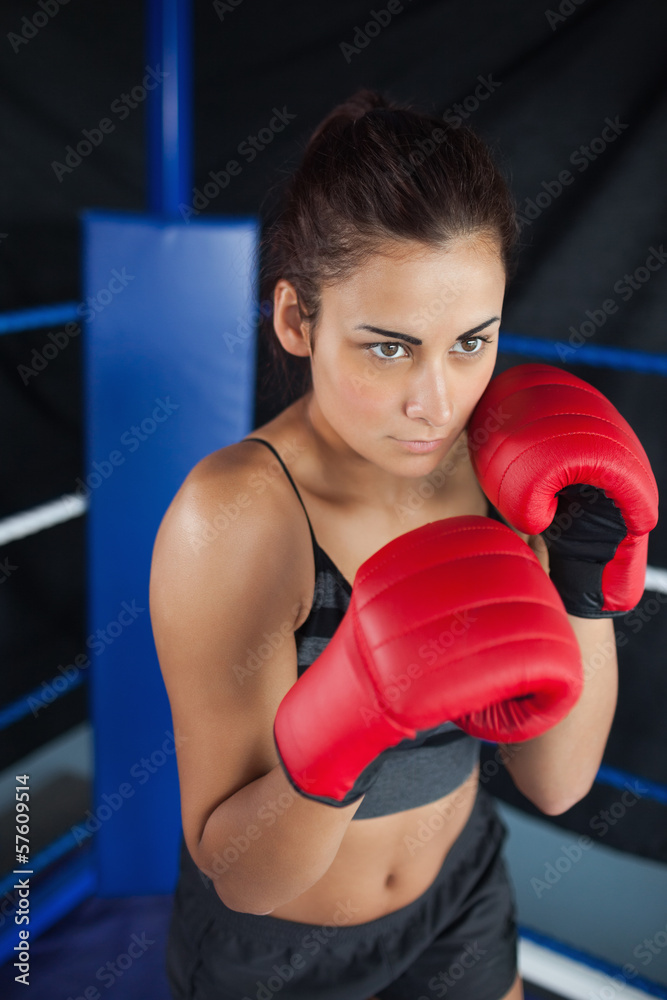 Determined woman in red boxing gloves