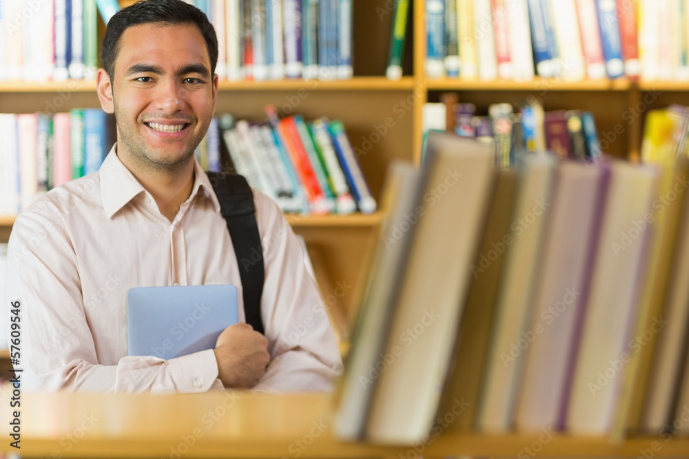 Smiling mature student with tablet PC in the library Smiling mature student with tablet PC in the library
