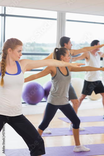 Fototapeta Naklejka Na Ścianę i Meble -  Sporty people stretching hands at yoga class in fitness studio