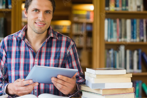 Mature student holding tablet PC in the library