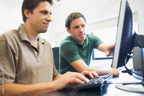 Teacher and mature student in computer room