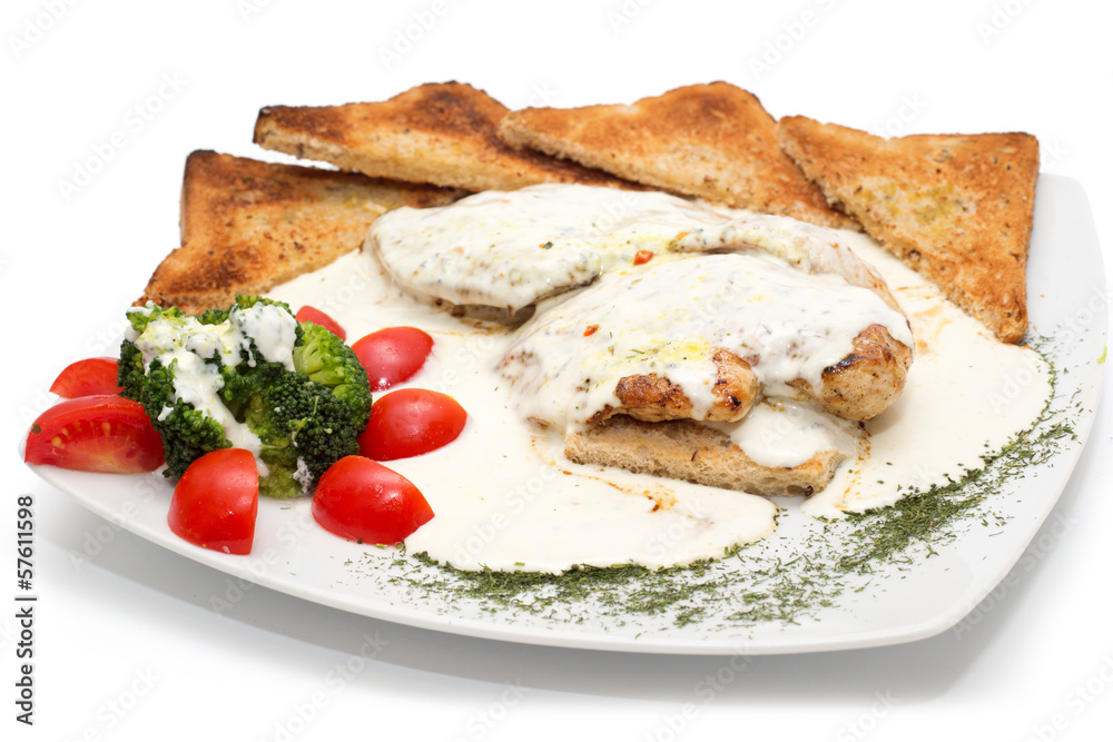 Chicken with gorgonzola, vegetables and bread on the plate