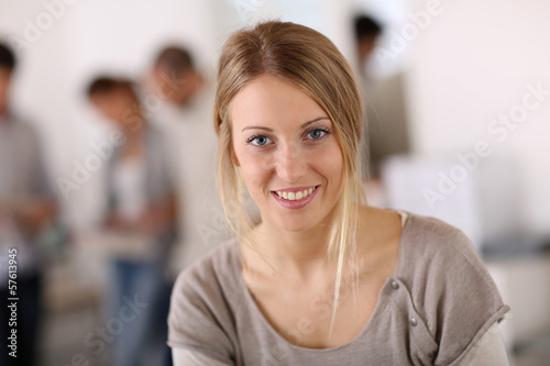 Young woman in office, people in background