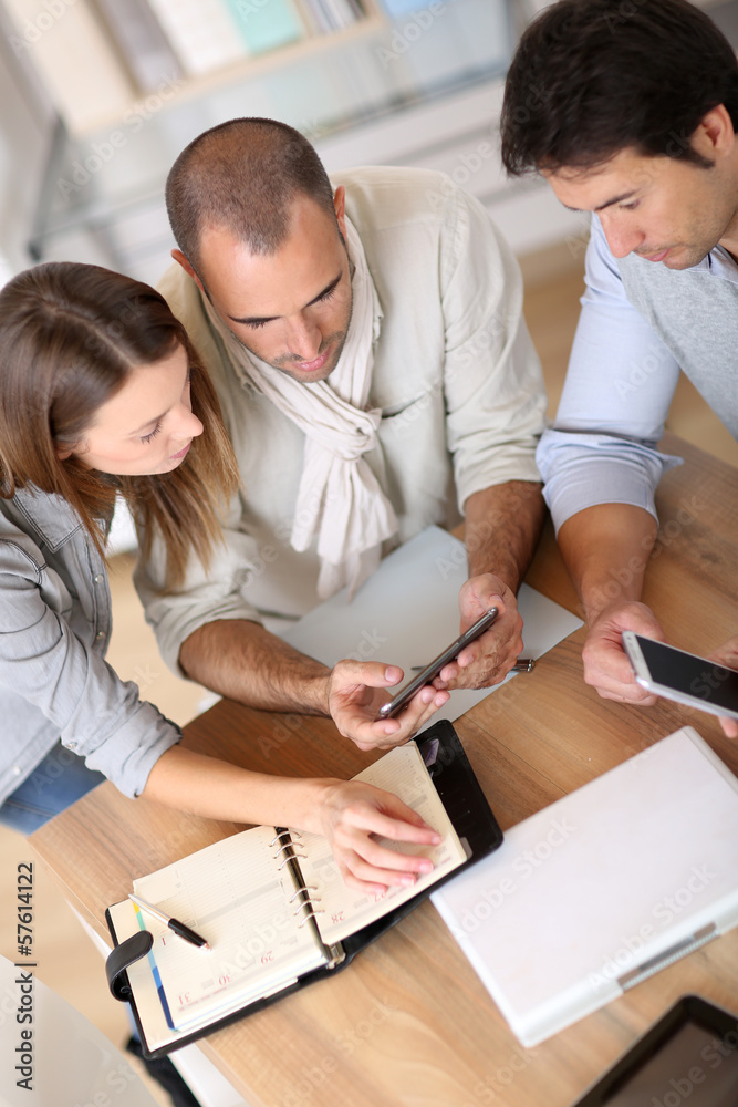 Fototapeta premium Business people using smartphone in meeting