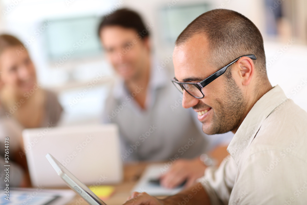 Young man in office working on digital tablet Young man in office working on digital tablet