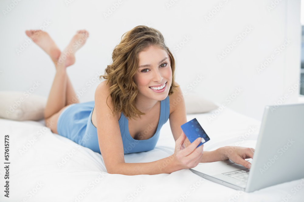 Content peaceful woman home shopping with notebook lying on her Content peaceful woman home shopping with notebook lying on her