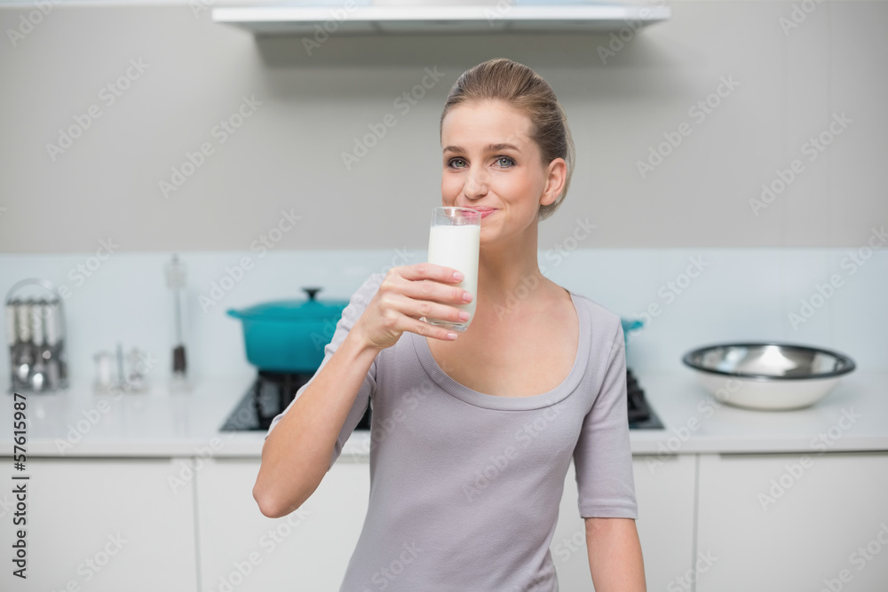 Smiling gorgeous model looking at camera drinking glass of milk Smiling gorgeous model looking at camera drinking glass of milk