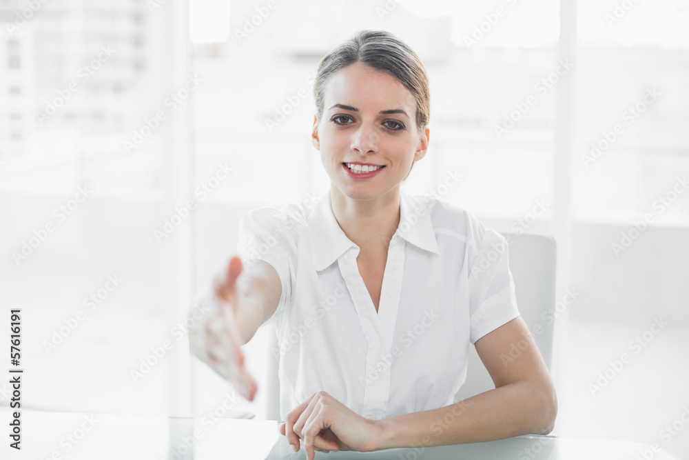 Polite young businesswoman reaching her hand to camera Polite young businesswoman reaching her hand to camera
