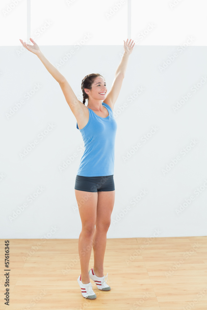 Happy woman in sportswear with raised hands