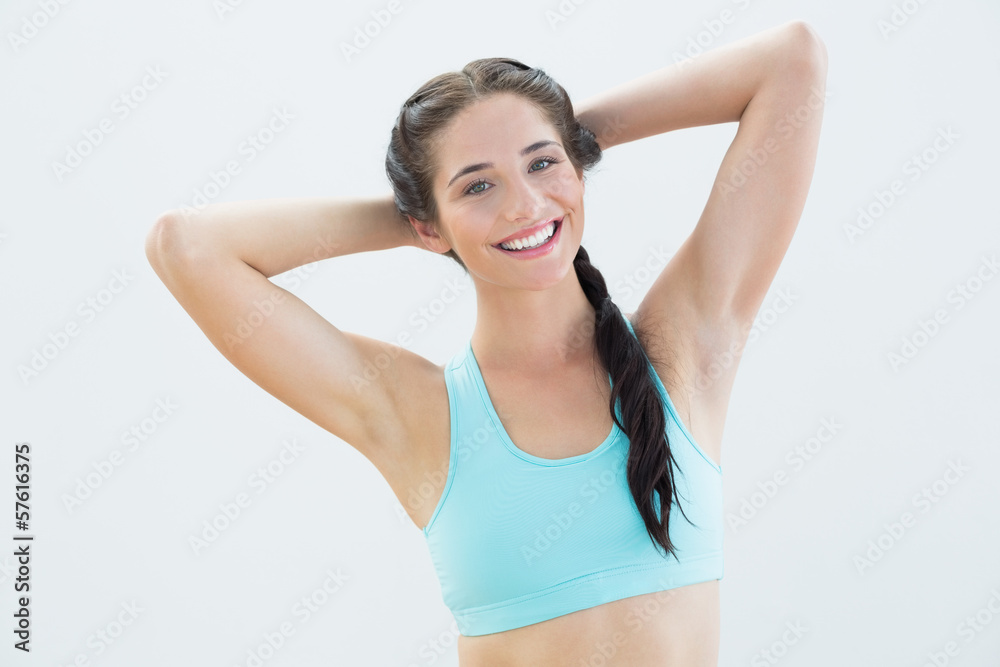 Portrait of a smiling woman with hands behind head