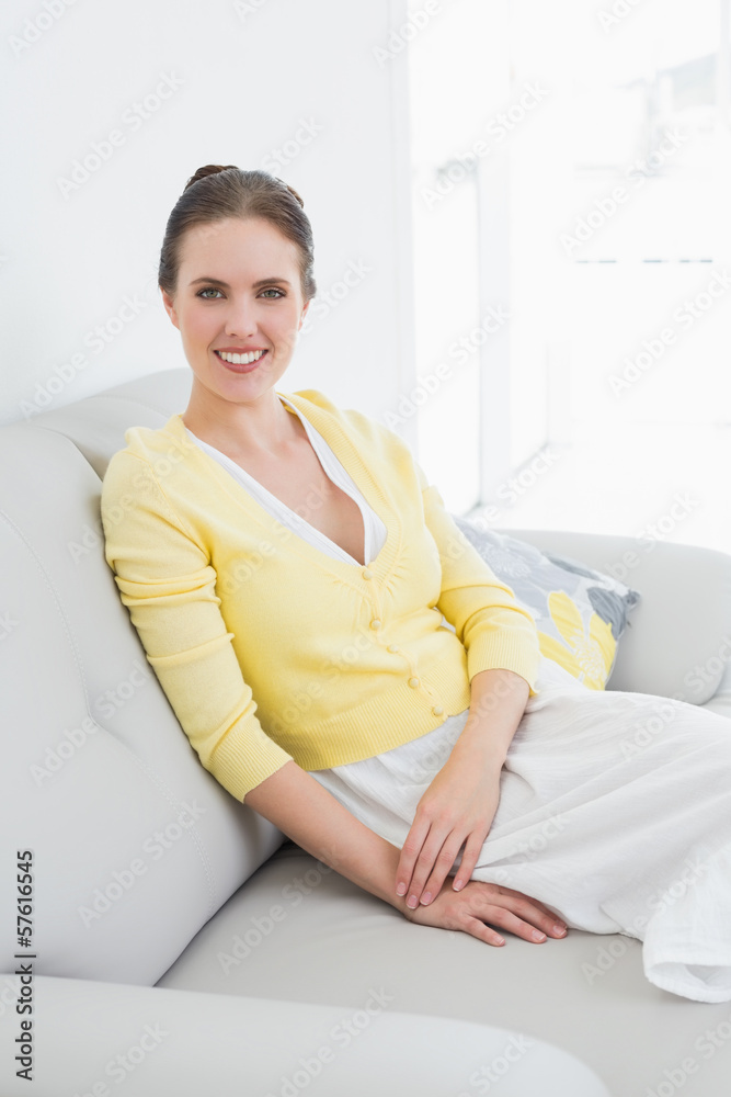 Smiling relaxed woman sitting on sofa at home Smiling relaxed woman sitting on sofa at home