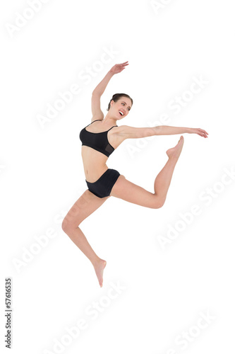 Sporty young woman jumping isolated on white background