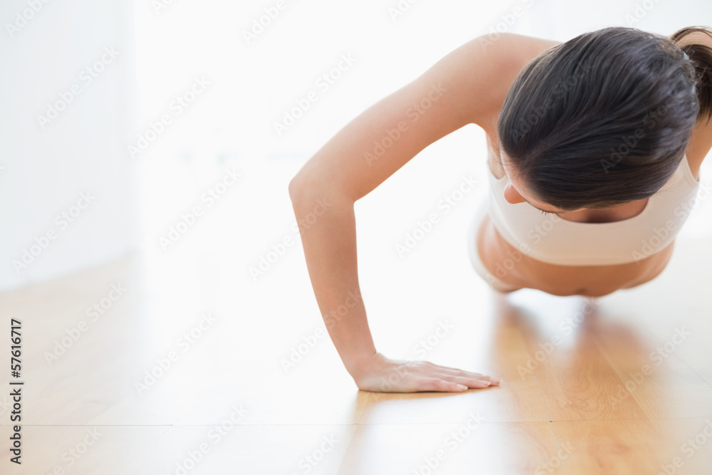 Fototapeta premium Sporty young woman doing push ups