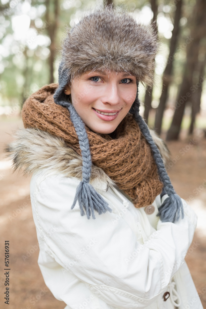 Woman in fur hat with woolen scarf and jacket in the woods Woman in fur hat with woolen scarf and jacket in the woods