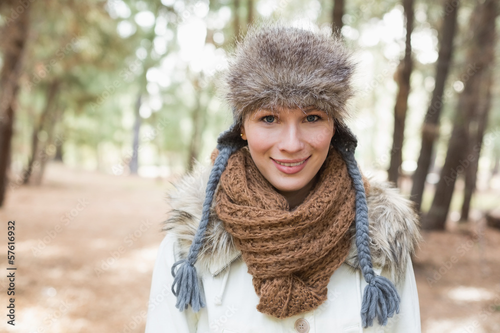 Woman wearing fur hat with woolen scarf and jacket in woods