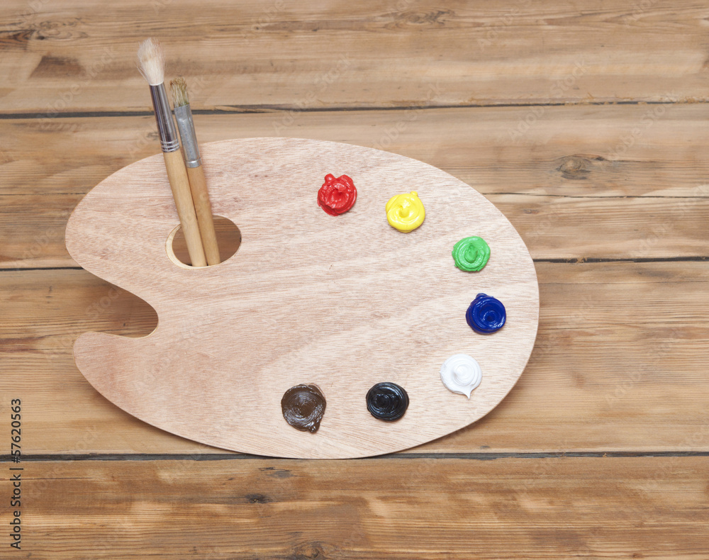 wooden art palette with paint and brushes on wooden background wooden art palette with paint and brushes on wooden background