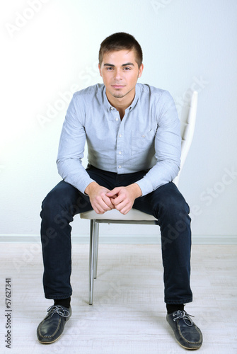 Guy sitting on chair in room