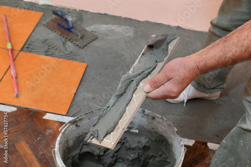 Home renovation, worker prepare tile with cement for placing