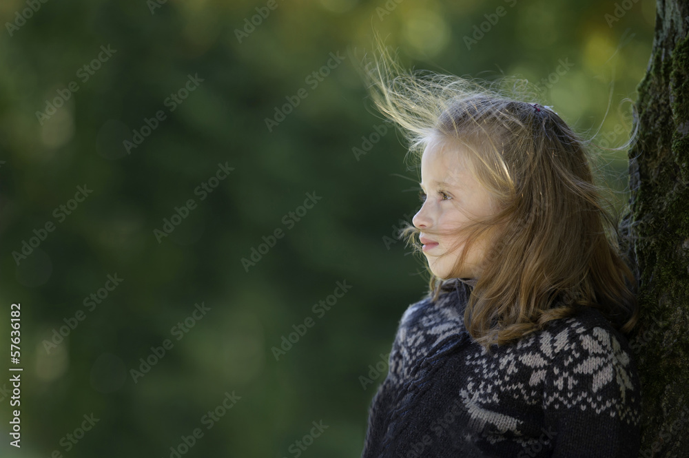 little blond girl seated against a tree little blond girl seated against a tree