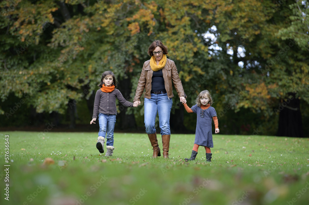 mother and daughters walking a the park mother and daughters walking a the park