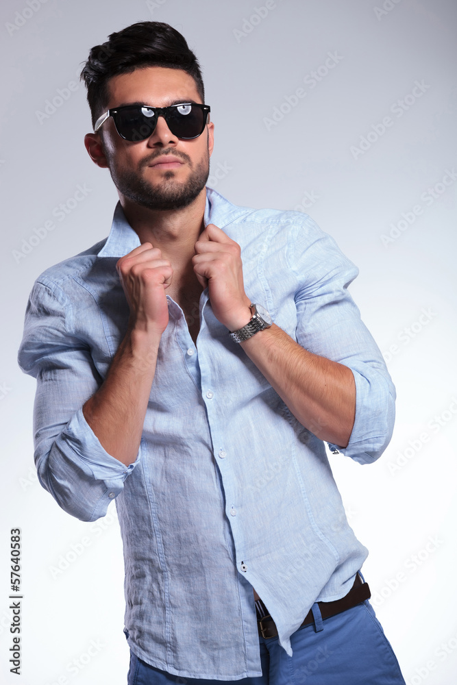 casual man adjusting his shirt and looking at you casual man adjusting his shirt and looking at you